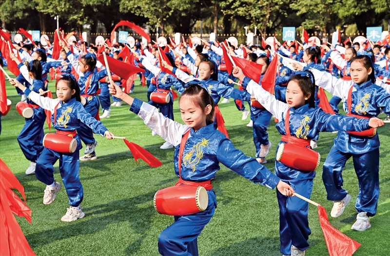 為助推民族地區(qū)基礎(chǔ)教育事業(yè)發(fā)展，廣西重新核定各地中小學(xué)教職工編制，依托全區(qū)編制“周轉(zhuǎn)池”核增事業(yè)編制給各地中小學(xué)，在全面達(dá)到國(guó)家標(biāo)準(zhǔn)的基礎(chǔ)上，進(jìn)一步統(tǒng)籌優(yōu)化和動(dòng)態(tài)調(diào)整各區(qū)域、學(xué)校、學(xué)段間編制資源。圖為2023年11月29日，南寧市濱湖路小學(xué)舉行主題為“逐夢(mèng)新時(shí)代 健體向未來”的體育文化節(jié)，孩子們正在跳腰鼓舞。 新華社記者 周華/攝