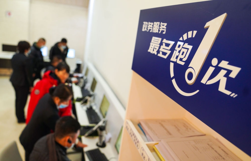 在吉林省長(zhǎng)春市二道區(qū)政務(wù)服務(wù)中心輔助填報(bào)區(qū)，市民在工作人員的輔助下進(jìn)行事項(xiàng)填報(bào)（2020年11月23日攝）。新華社記者 許暢 攝