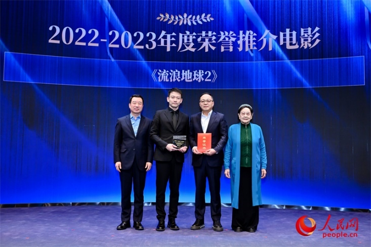 著名電影藝術(shù)家、事業(yè)家王曉棠（右一）和中國(guó)文聯(lián)書記處書記張宏（左一）為《流浪地球2》出品人、總監(jiān)制、總制片人傅若清（右二）與導(dǎo)演郭帆（左二）頒發(fā)“2022-2023年度榮譽(yù)推介電影”