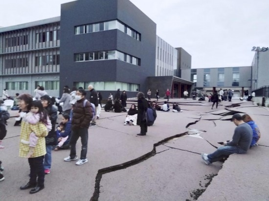  1月1日，在日本石川縣輪島市，人們站在被地震破壞的地面上。新華社/共同社