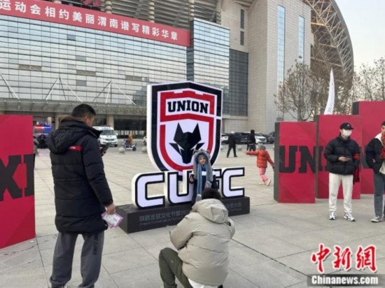 球迷們與隊(duì)徽合影。記者 卞立群 攝