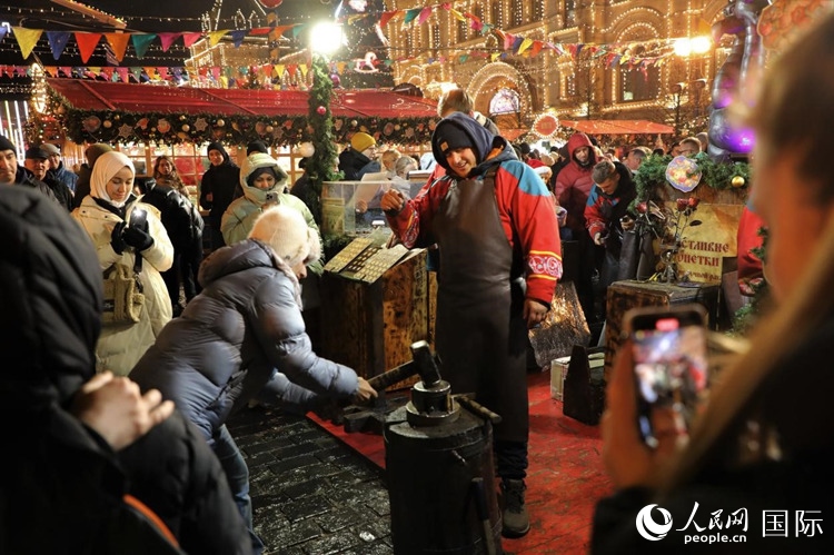 游客在新年集市上體驗(yàn)制作紀(jì)念幣。人民網(wǎng)記者 隋鑫攝