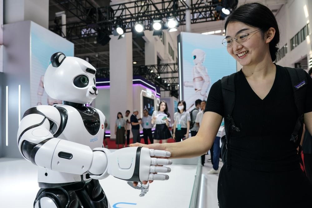 2023年8月16日，一名女士在北京舉辦的2023世界機器人大會現(xiàn)場與智能機器人握手。新華社記者彭子洋攝
