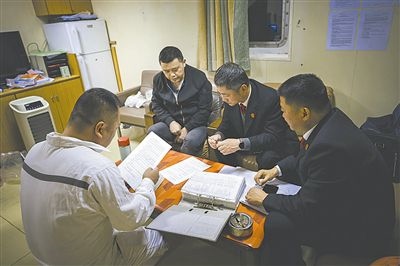 圖②：法官向船長講解相關(guān)法律規(guī)定，查看船舶資料，并與船方辦理扣押船舶的手續(xù)。