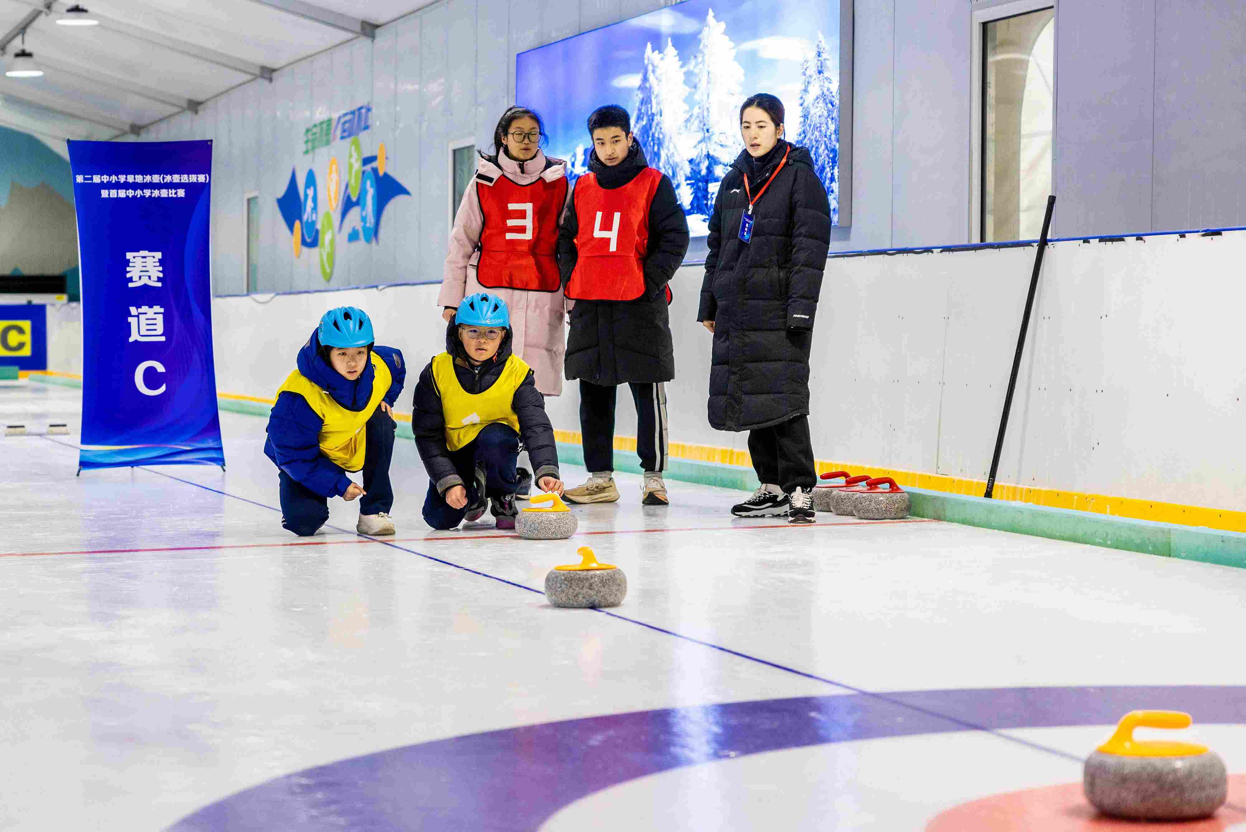 2023年12月10日，參賽選手在呼和浩特首屆中小學(xué)冰壺比賽中投擲冰壺。