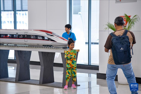 1月24日，在印度尼西亞雅加達哈利姆站候車大廳，一名小朋友和雅萬高鐵高速動車組模型合影。新華社記者 徐欽 攝