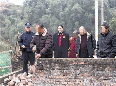  圖③：庭審結(jié)束后，在法官的見證下，陳某在院壩邊重新開鑿一條通道。