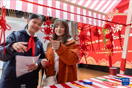 1月28日，復(fù)旦大學(xué)第二附屬學(xué)校學(xué)生（左）為美國馬斯卡廷中學(xué)學(xué)生（右）介紹中國結(jié)。 新華社記者 王翔 攝