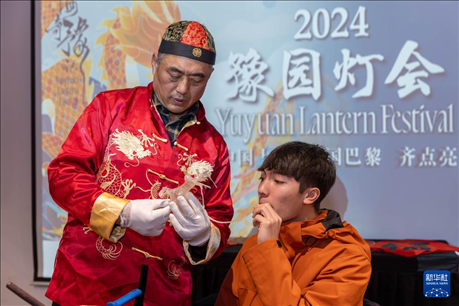 1月28日，在上海豫園舉行的民俗活動(dòng)上，美國馬斯卡廷中學(xué)學(xué)生在非遺傳承人的指導(dǎo)下吹糖偶。 新華社記者 王翔 攝