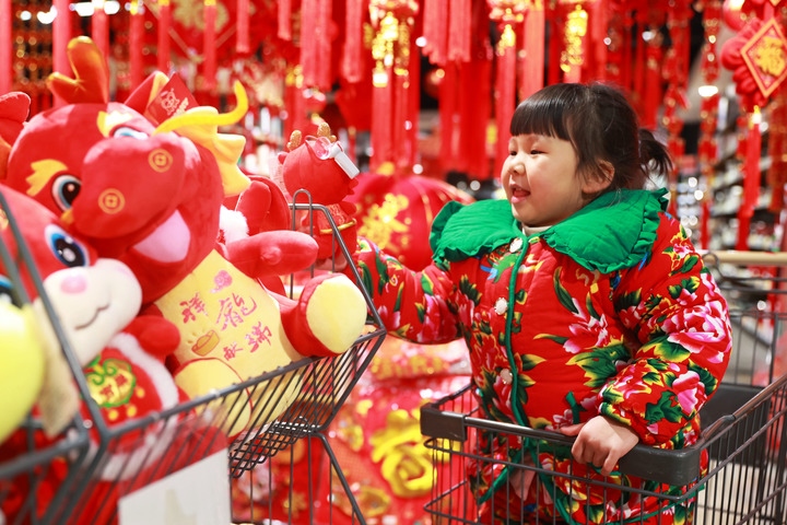1月23日，在貴州省黔東南苗族侗族自治州岑鞏縣一家超市，小朋友在家人的帶領(lǐng)下選購(gòu)龍年毛絨玩具。新華社發(fā)（唐鵬攝）