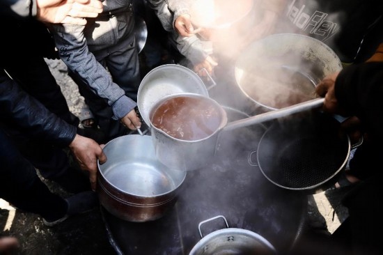  2月27日，在加沙地帶北部的杰巴利耶難民營，人們領(lǐng)取食物。新華社發(fā)（穆罕默德·阿里攝）