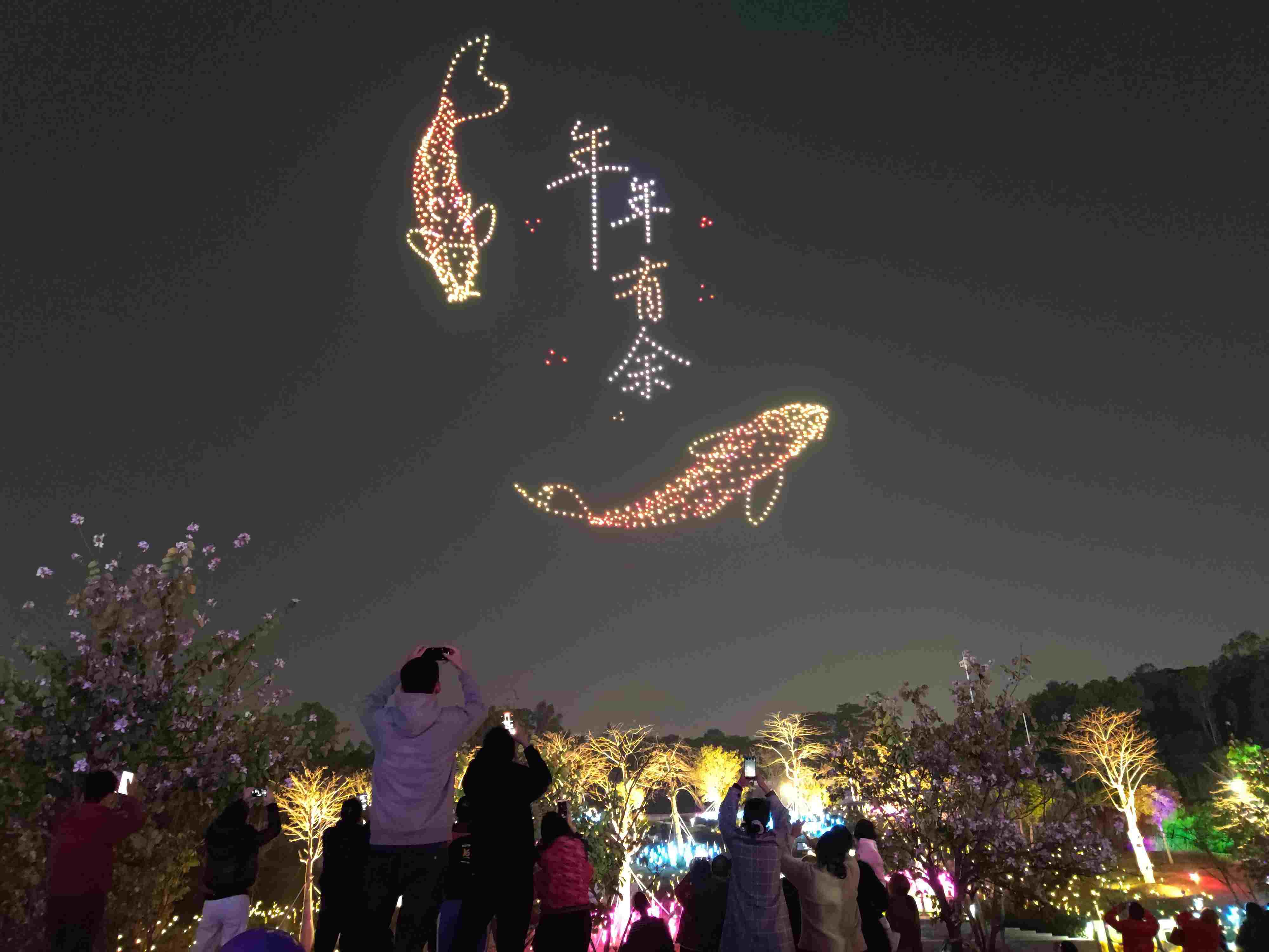 △ 2024年2月10日，深圳北站中心公園，春節(jié)主題無人機(jī)燈光秀引來眾多游客駐足觀看。
