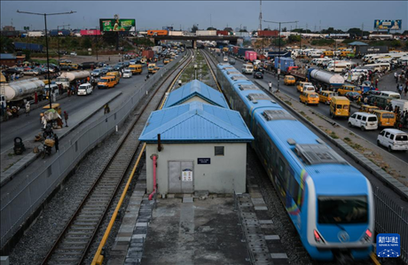 3月4日，在尼日利亞拉各斯，一列輕軌藍(lán)線列車行駛至公路交通擁堵路段附近。新華社記者 韓旭 攝