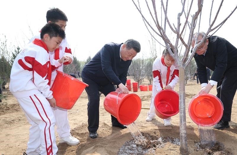 2024年4月3日，習(xí)近平總書(shū)記同少先隊(duì)員一起給剛栽下的樹(shù)苗澆水。