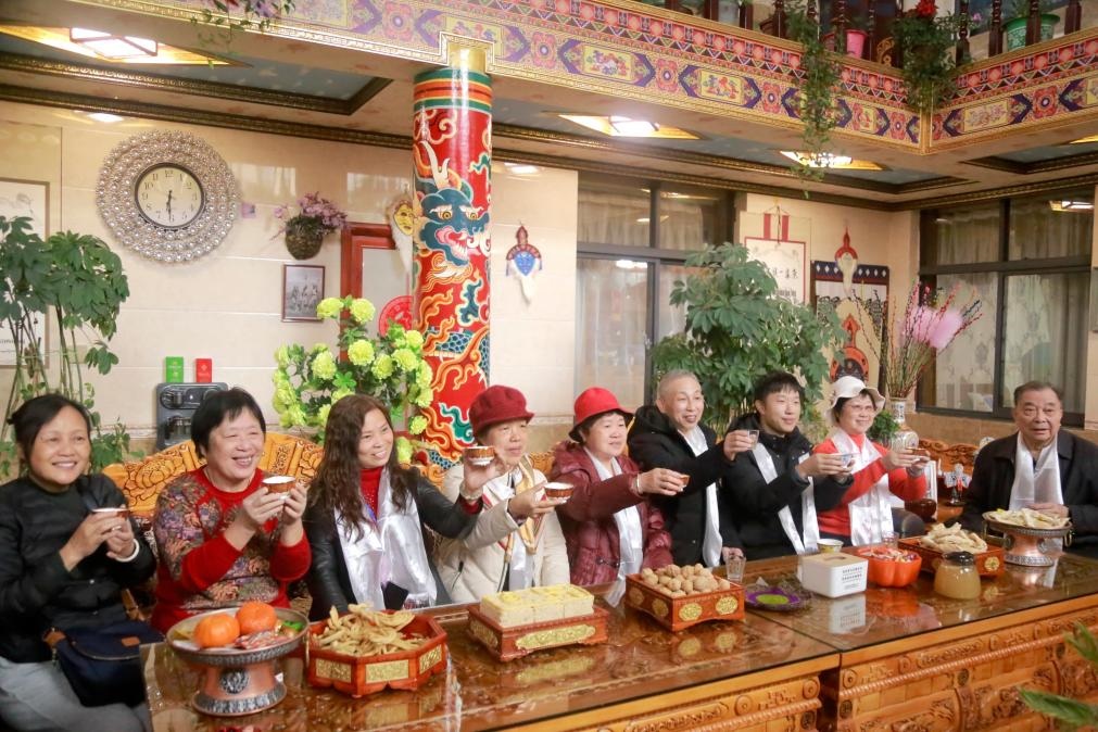 游客們?nèi)胱∶袼藓螅e杯共飲酥油茶。新華社記者 邱星翔 攝