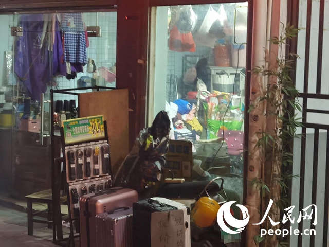 南寧“城中村”一裁縫鋪老板將電線從店內(nèi)拉出為電動(dòng)自行車充電。人民網(wǎng) 覃心攝