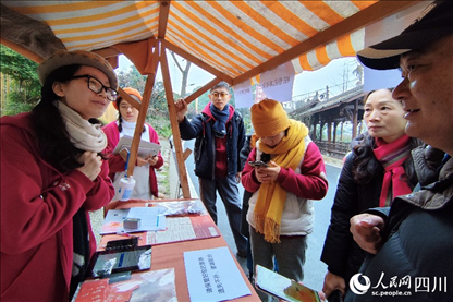 1月6日，“2024成都蒲江柑甜采摘節(jié)”上，記者見到了小萌（左一）和許多年輕人忙著做訪客接待、現(xiàn)場(chǎng)布置、票務(wù)核對(duì)、采摘服務(wù)等工作。人民網(wǎng)記者朱虹攝