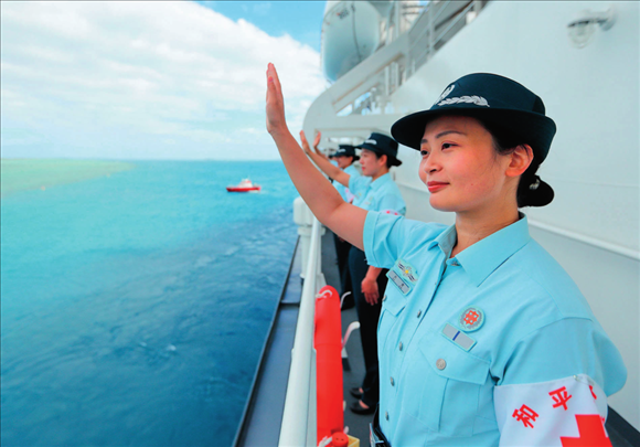 中國(guó)海軍“和平方舟”號(hào)醫(yī)院船結(jié)束訪問湯加時(shí)，任務(wù)官兵中的文職人員向歡送人群揮手告別（2023年8月4日攝）。徐巍攝/本刊