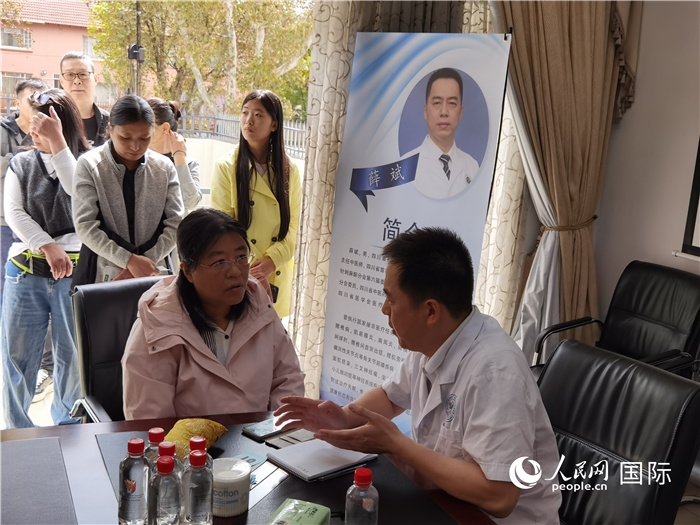 中醫(yī)專家為當?shù)厝A僑華人提供中醫(yī)咨詢和診療服務(wù)。 （本報記者 楊謳 攝）