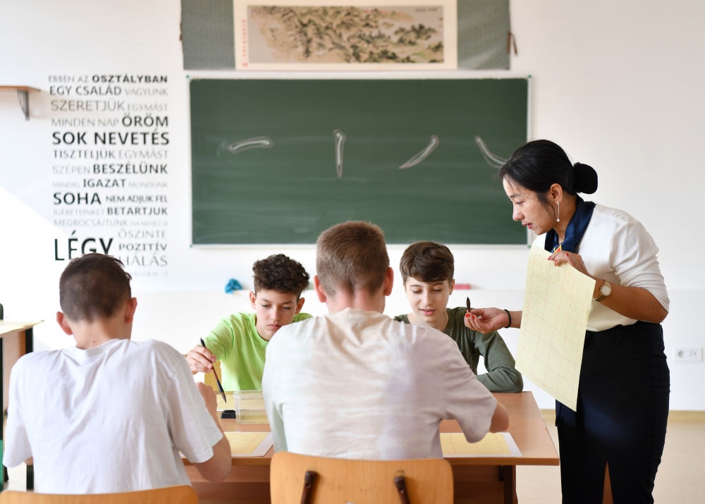 2023年2月24日，在匈牙利首都布達佩斯的匈中雙語學校，中國教師指導學生們學習書法。新華社記者 連漪 攝