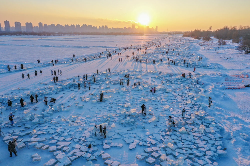 2024年1月7日，在封凍的松花江哈爾濱段，游客在日落時分的“鉆石海”游玩（無人機照片）。新華社記者 謝劍飛 攝