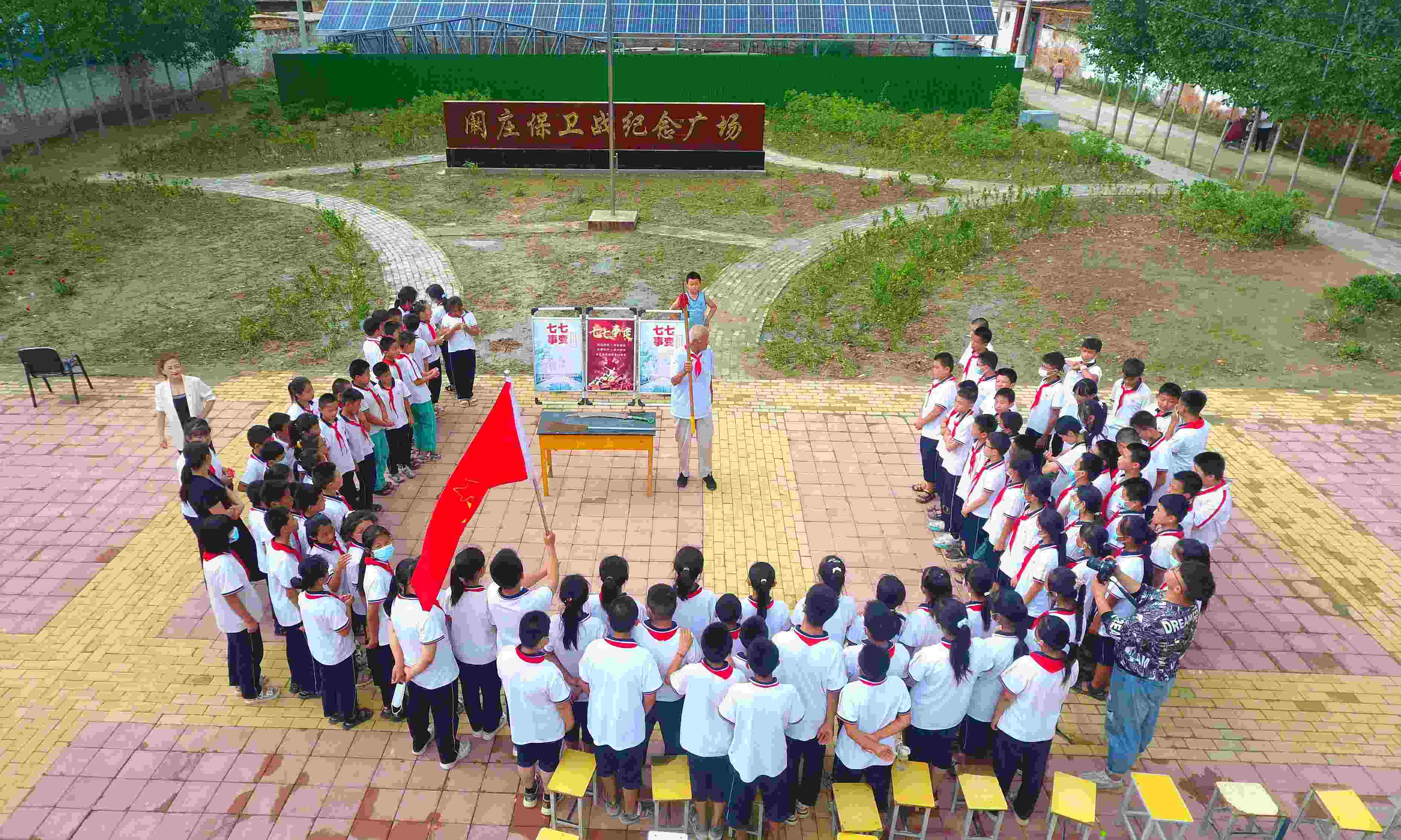 2022年7月6日，山東省聊城市，在茌平區(qū)菜屯鎮(zhèn)闞莊村的闞莊保衛(wèi)戰(zhàn)紀(jì)念廣場，闞莊保衛(wèi)戰(zhàn)親歷者王光木老人為小學(xué)生們講述抗戰(zhàn)故事，展示大刀、長矛。