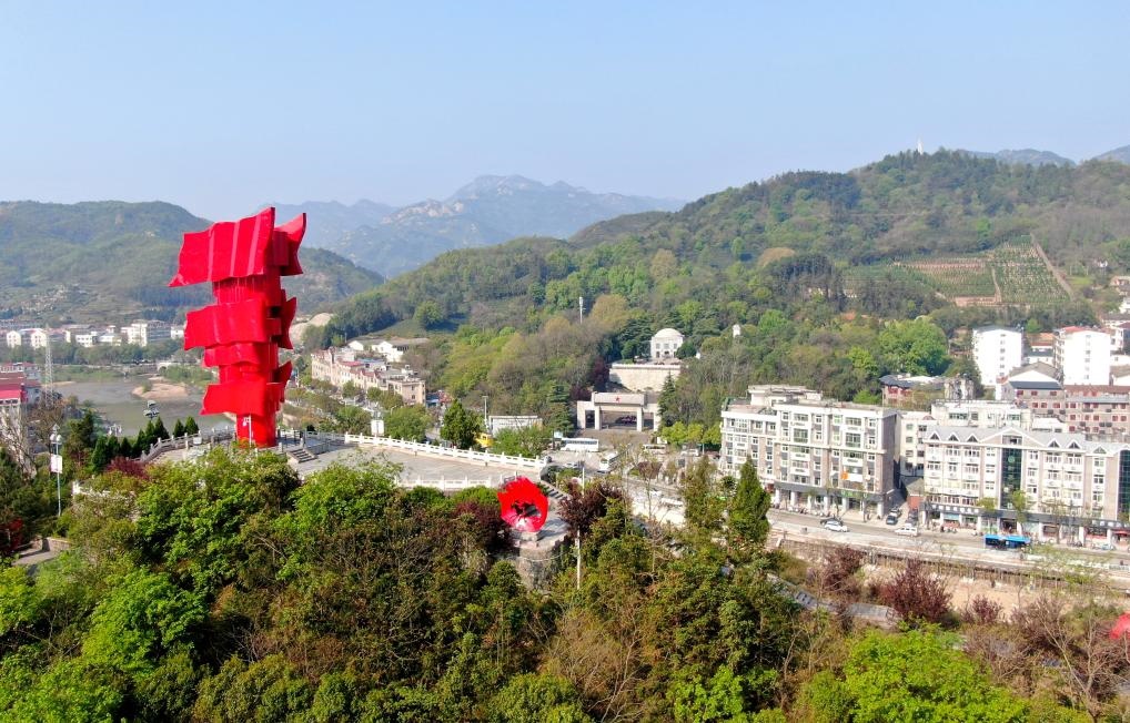 這是2021年4月9日拍攝的鄂豫皖蘇區(qū)首府革命博物館附近的英雄山上的“紅旗飄飄”主題雕塑（無人機(jī)照片）。新華社發(fā)