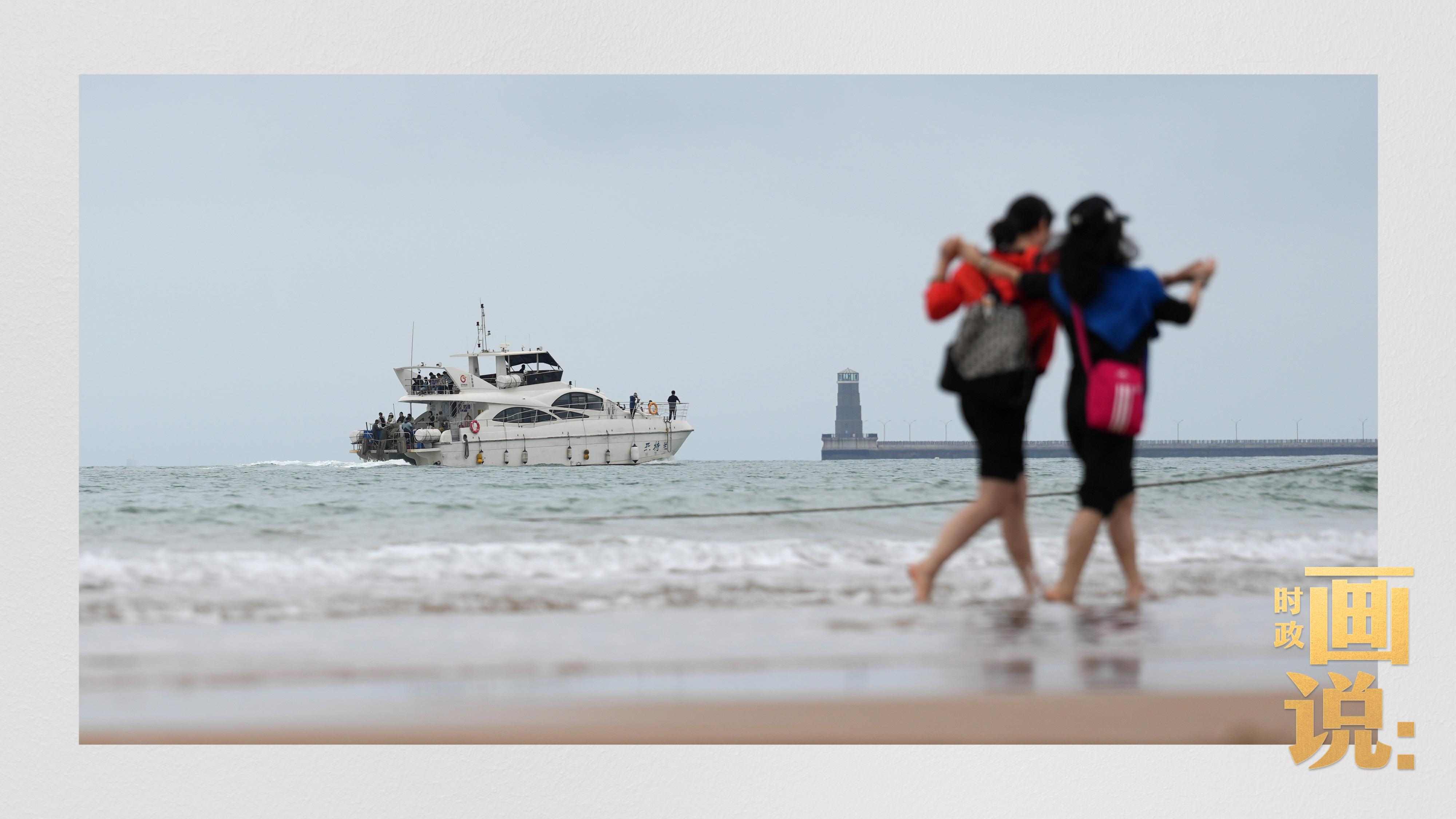 △日照陽光海岸綠道上的萬平口景區(qū)，一對游客在海浪中翩然起舞。