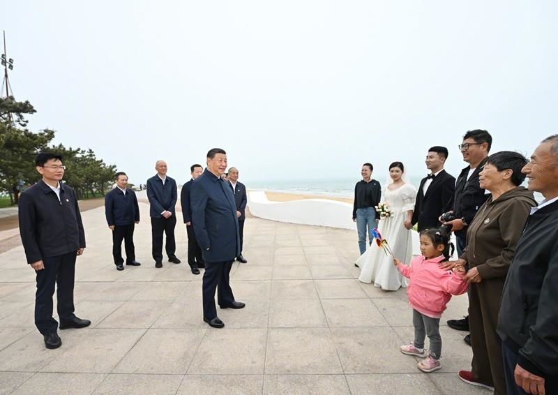 5月22日，在山東日照考察調(diào)研的習近平總書記來到陽光海岸綠道，同市民游客親切交流。