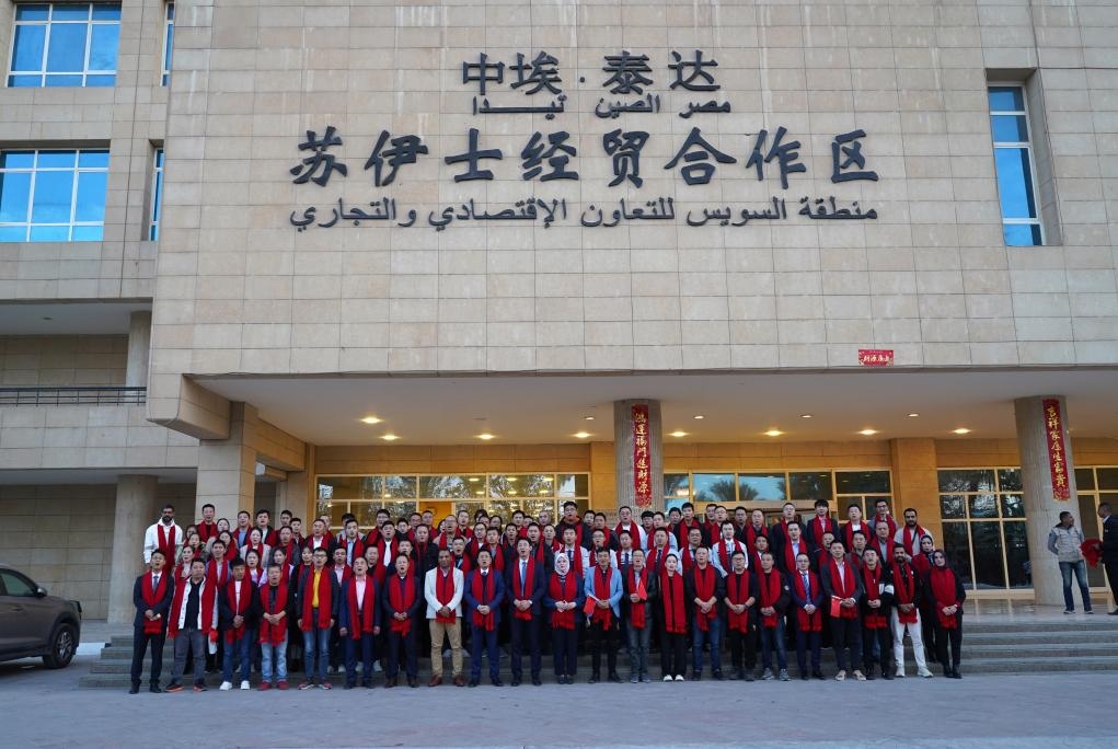 2024年2月11日，在位于埃及蘇伊士省的中?！ぬ┻_(dá)蘇伊士經(jīng)貿(mào)合作區(qū)，中埃員工在合作區(qū)辦公大樓前合影拜年。新華社發(fā)（泰達(dá)合作區(qū)供圖）