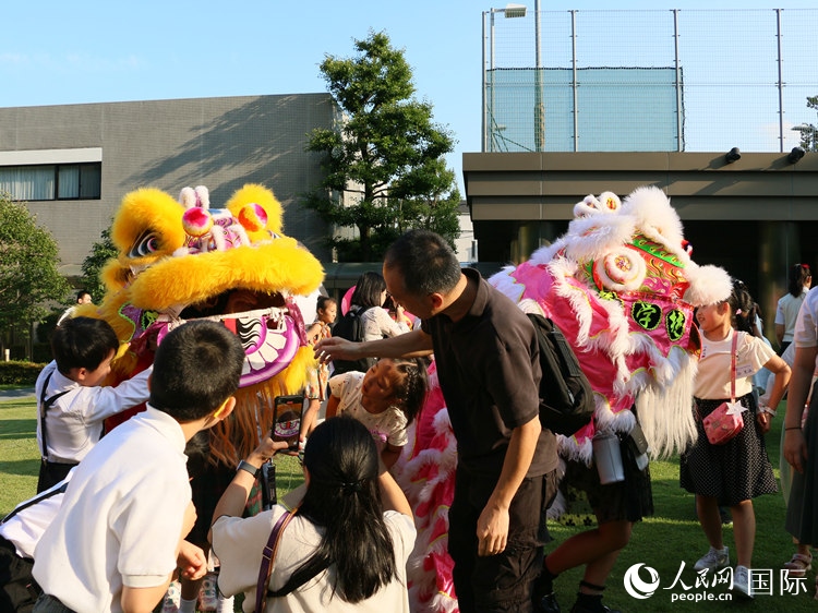 孩子們好奇地圍觀舞獅。人民網(wǎng) 許可攝