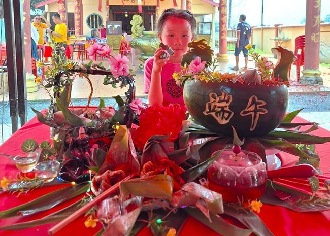 小朋友展示學(xué)裹粽子的成品照。組委會(huì)供圖