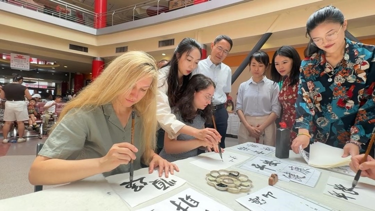 羅馬尼亞友人在活動現(xiàn)場學(xué)寫漢字。中國駐羅馬尼亞大使館領(lǐng)僑處供圖