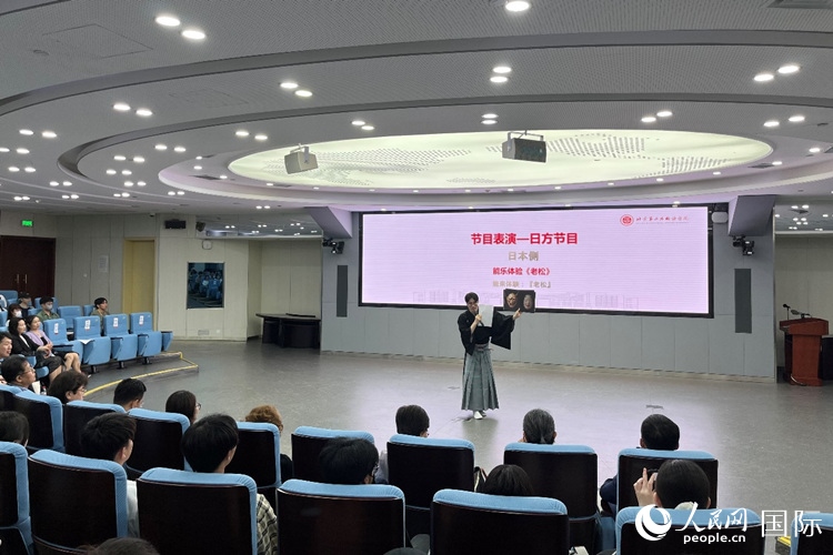 日本大學(xué)生介紹能樂知識。人民網(wǎng)記者 陳思攝