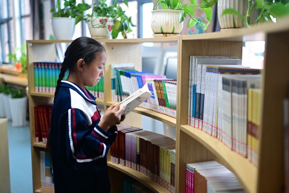 6月18日，果洛西寧民族中學(xué)學(xué)生尼東拉毛在圖書室看書。