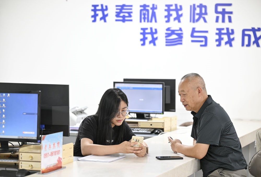 6月20日，在長城花園社區(qū)黨群服務(wù)中心，工作人員幫助居民辦理業(yè)務(wù)。