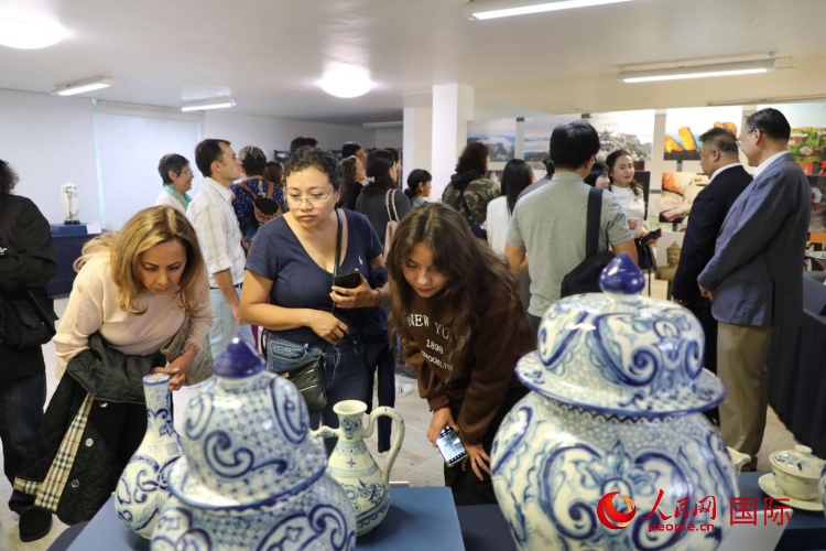在展覽現(xiàn)場(chǎng)，觀眾們駐足欣賞德化瓷和墨西哥彩瓷。人民網(wǎng) 埃內(nèi)斯托·多明戈斯攝