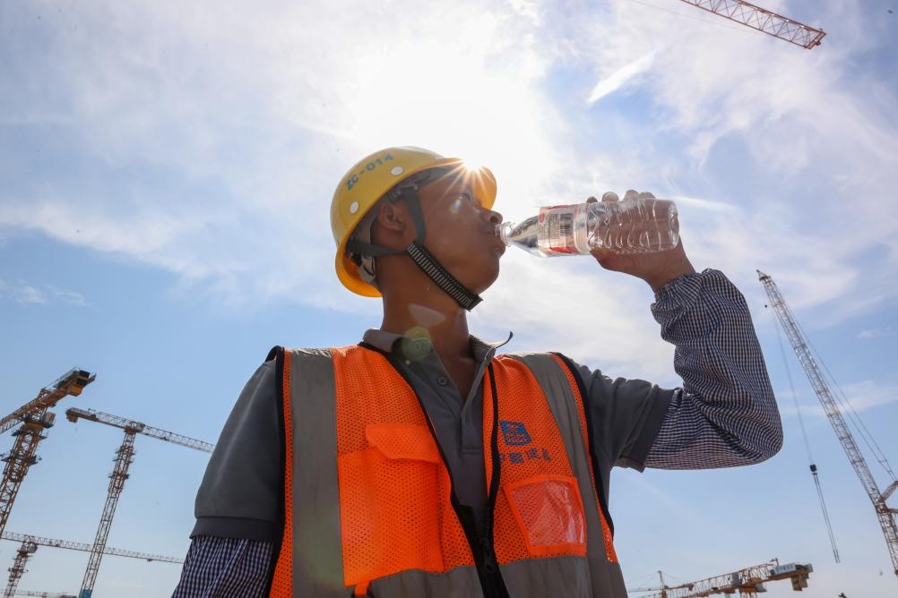 6月18日，在江蘇省無錫市奧體三期項目施工現(xiàn)場，中建二局工人在喝水解暑。新華社發(fā)（朱吉鵬 攝）