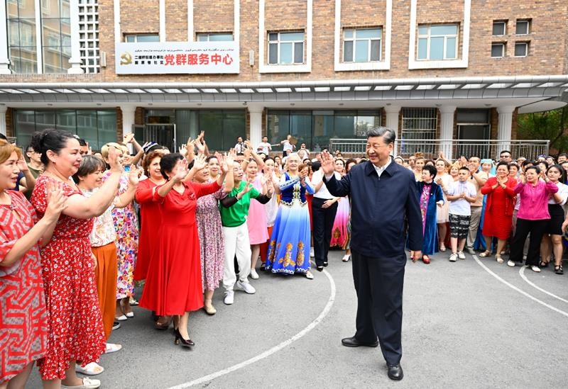 2022年7月13日，習(xí)近平總書記在新疆烏魯木齊市天山區(qū)固原巷社區(qū)考察時，向各族群眾揮手致意。