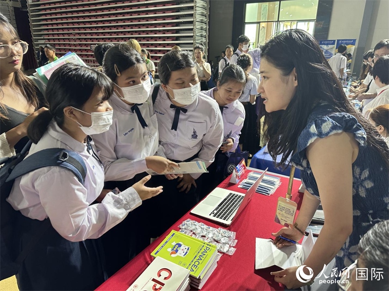 來自泰國的學生、家長在教育展臺前咨詢。人民網(wǎng)記者 簡承淵攝