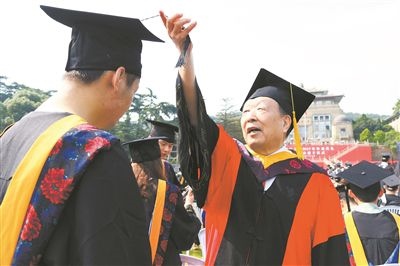 2017年6月22日，李德仁（右一）參加武漢大學(xué)畢業(yè)典禮并為畢業(yè)生撥穗。
