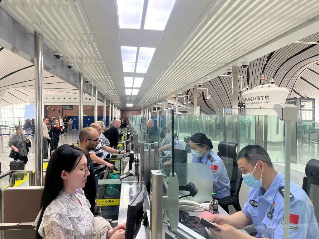 7月5日，北京大興國(guó)際機(jī)場(chǎng)邊檢站民警正在辦理邊檢查驗(yàn)手續(xù)。（北京大興國(guó)際機(jī)場(chǎng)邊檢站供圖）