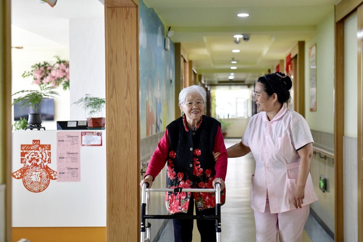 2024年5月25日，在山東省日照市東港區(qū)石臼街道日照幸福護(hù)理院，工作人員在陪護(hù)老人。新華社記者 郭緒雷 攝