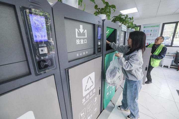 2024年4月10日，在浙江省湖州市吳興區(qū)飛英街道新華府小區(qū)內(nèi)，居民在垃圾分類智能系統(tǒng)的指導(dǎo)下進(jìn)行垃圾分類投放，居民的投放情況將實(shí)時(shí)匯總到智慧服務(wù)平臺(tái)，會(huì)有相應(yīng)的積分獎(jiǎng)勵(lì)。新華社記者 徐昱 攝