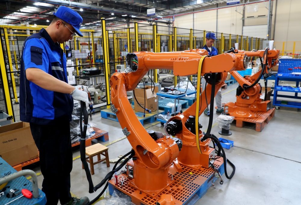 工作人員在上海新時(shí)達(dá)機(jī)器人有限公司位于嘉定的智能工廠內(nèi)忙碌（2024年5月23日攝）。新華社記者 龔兵 攝