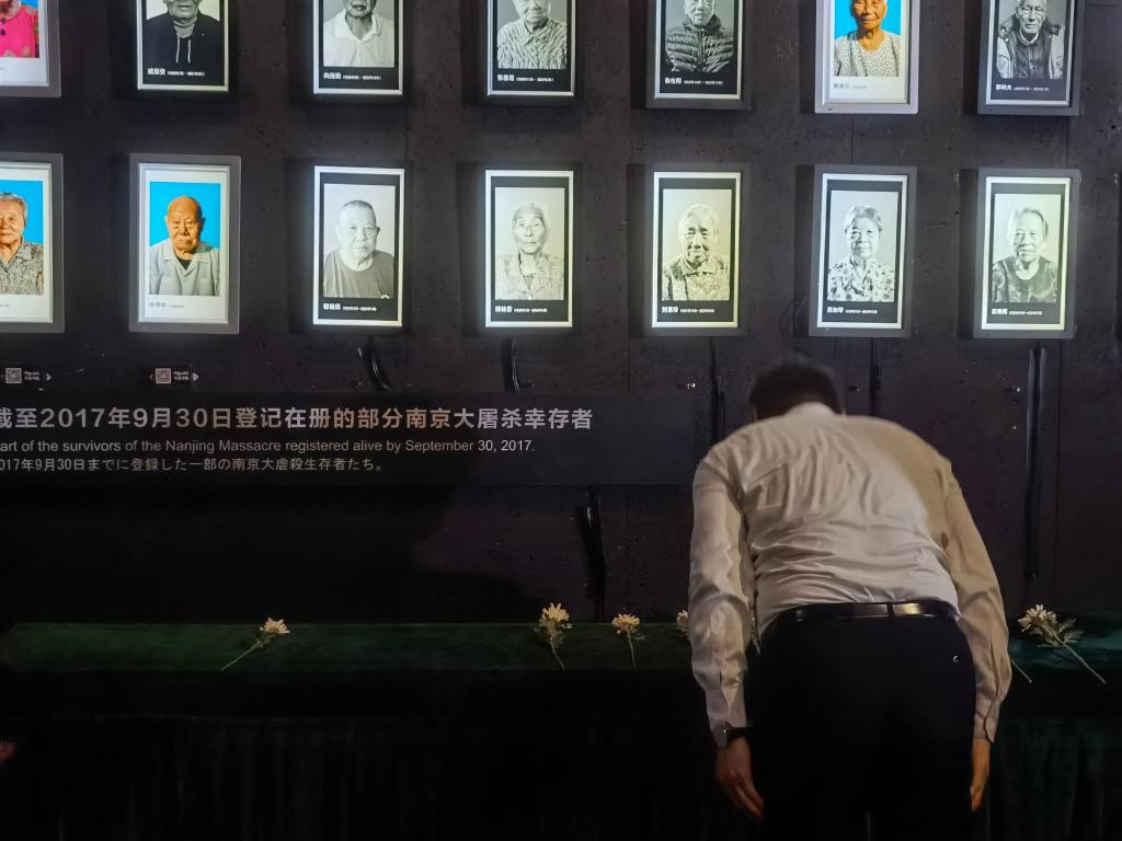 7月18日，人們向離世的南京大屠殺幸存者獻(xiàn)花、鞠躬。新華社記者邱冰清 攝