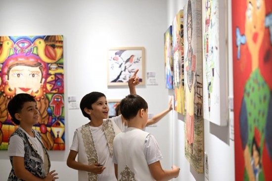 外國藝術團成員在參觀藝術節(jié)期間舉辦的世界兒童繪畫展覽。新華社記者 趙子碩 攝