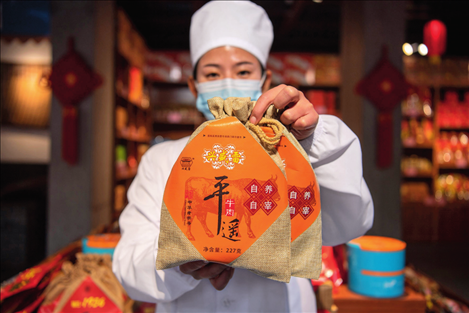 在位于山西省晉中市平遙縣的平遙古城南大街的一家平遙牛肉店內(nèi)，工作人員展示一款牛肉產(chǎn)品（資料照片）楊晨光攝 / 本刊