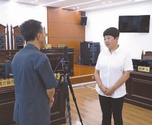 圖為全國人大代表玉明姬（右）詳細了解環(huán)境資源審判工作情況。劉思妤 攝