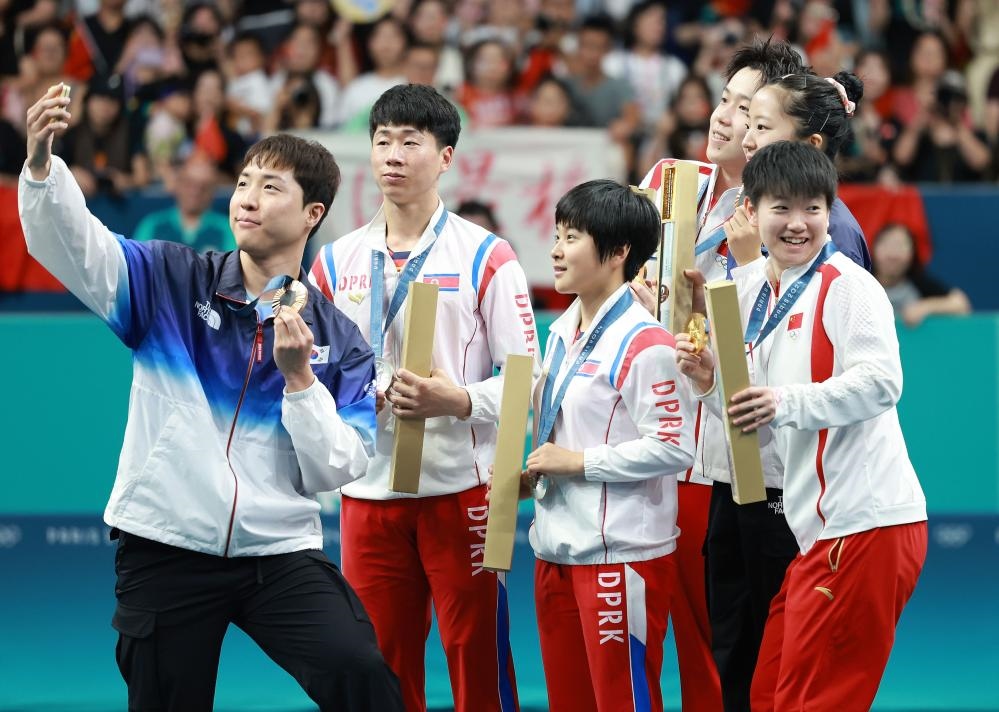 冠軍中國組合王楚欽（右三）/孫穎莎（右一）、亞軍朝鮮組合李正植（左二）/金琴英（左三）、季軍韓國組合林鐘勛（左一）/申裕斌在巴黎奧運會乒乓球混雙頒獎儀式上合影（2024年7月30日攝）。新華社記者 劉續(xù) 攝
